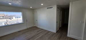 Interior space with dark wood-type flooring and a textured ceiling