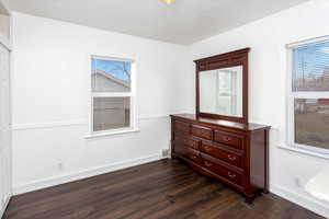 Bedroom featuring dark hardwood / wood-style flooring and multiple windows