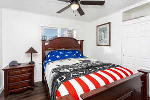 Bedroom with dark hardwood / wood-style floors and ceiling fan