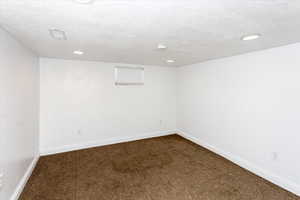 Spare room with carpet floors and a textured ceiling