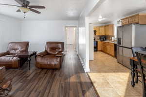 Interior space with ceiling fan, decorative backsplash, light wood-type flooring, and black appliances