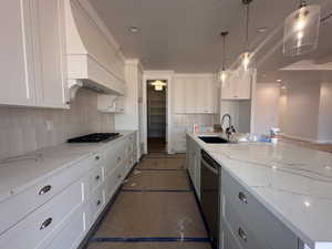Kitchen featuring appliances with stainless steel finishes, decorative backsplash, white cabinets, and pendant lighting