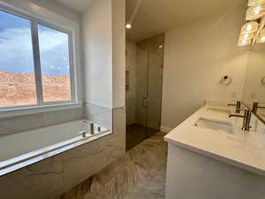 Full bathroom featuring double vanity, a bath, and a marble finish shower