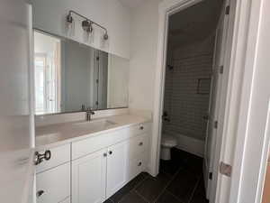 Bathroom featuring vanity, tile patterned floors, and  shower combination