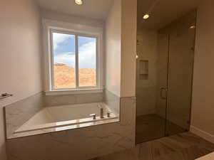 Bathroom with a marble finish shower, a garden tub, healthy amount of natural light, and recessed lighting