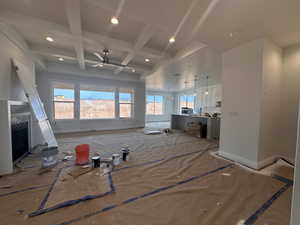 Unfurnished living room with recessed lighting, coffered ceiling, ceiling fan, beam ceiling, and a fireplace