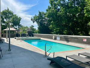 View of pool with a gazebo, an outdoor fireplace, and a patio