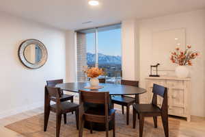 Dining space with floor to ceiling windows, a mountain view, and light wood-type flooring