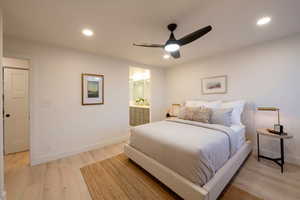 Bedroom with connected bathroom, light hardwood / wood-style flooring, and ceiling fan