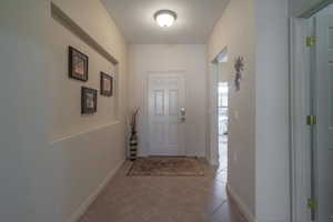 Doorway featuring light tile patterned flooring