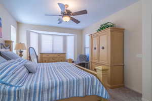 Carpeted bedroom featuring ceiling fan