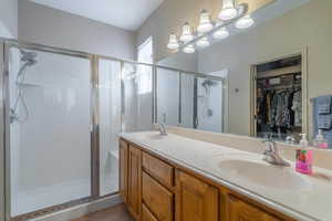 Bathroom featuring tile patterned floors, vanity, and a shower with door