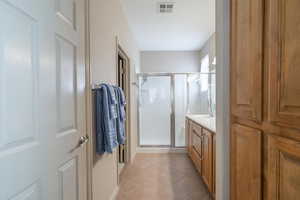 Bathroom with tile patterned floors, an enclosed shower, and vanity