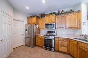 Kitchen featuring stainless steel appliances, sink, and light tile patterned floors