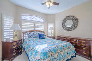 Carpeted bedroom featuring ceiling fan