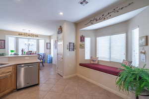 Kitchen featuring pendant lighting, dishwasher, light tile patterned floors, and a notable chandelier