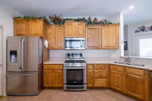 Kitchen with stainless steel appliances, sink, and light tile patterned floors