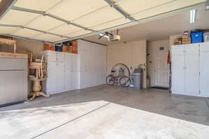 Garage featuring a garage door opener and white fridge