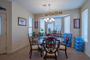 Tiled dining room with an inviting chandelier