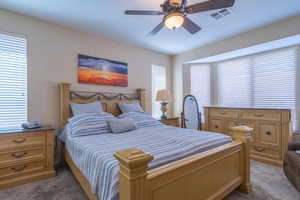 Carpeted bedroom featuring ceiling fan