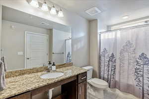 Full bathroom featuring vanity, toilet, and shower / bath combo with shower curtain