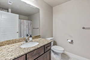 Bathroom featuring vanity, tile patterned floors, and toilet