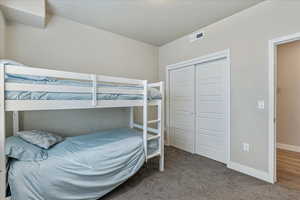 Carpeted bedroom featuring a closet