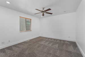 Empty room with visible vents, baseboards, a ceiling fan, dark carpet, and recessed lighting