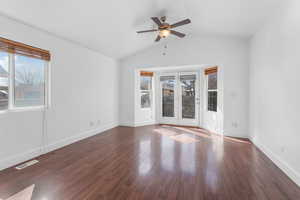 Unfurnished room featuring baseboards, visible vents, lofted ceiling, ceiling fan, and wood finished floors