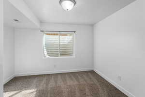 Carpeted empty room featuring visible vents and baseboards