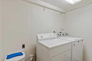 Laundry area featuring washing machine and dryer and a textured ceiling