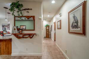 Hallway with sink and light tile patterned floors