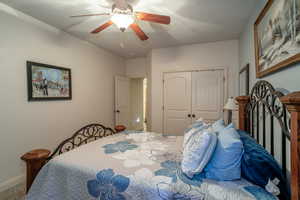 Bedroom featuring carpet flooring, ceiling fan, and a closet