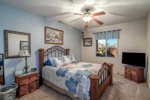 Carpeted bedroom featuring ceiling fan