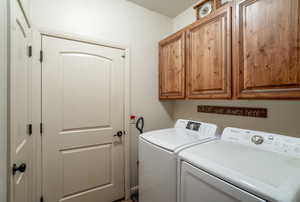 Laundry room with separate washer and dryer and cabinets