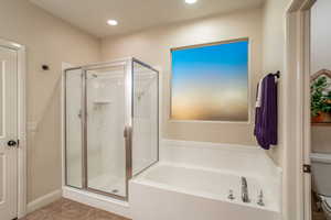 Bathroom featuring tile patterned flooring and separate shower and tub