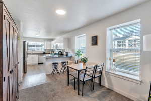 Dining space featuring sink, light hardwood / wood-style floors, and a textured ceiling