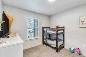 Bedroom featuring light carpet