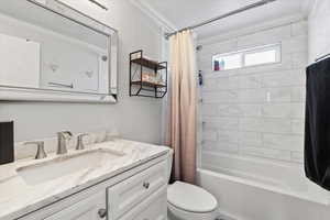 Full bathroom with shower / bath combo, vanity, and toilet