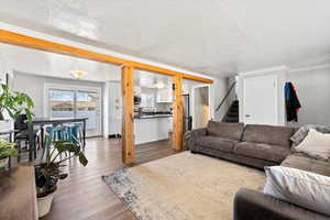 Living room featuring ornamental molding, hardwood / wood-style floors, and a textured ceiling