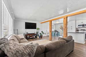 Living room featuring ornamental molding, hardwood / wood-style floors, and a textured ceiling