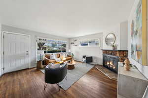 Living room with dark wood-type flooring and a fireplace