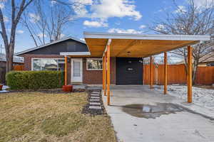 View of front of home with a carport and a front yard