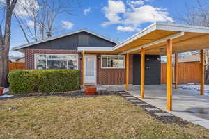 View of front of house featuring a carport and a front yard