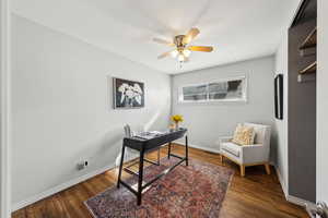 Office area featuring dark wood-type flooring and ceiling fan