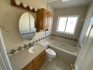 Full bathroom featuring shower / washtub combination, vanity, tasteful backsplash, tile patterned floors, and toilet