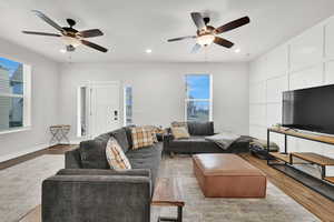 Living room featuring ceiling fan, a healthy amount of sunlight, and light wood-type flooring