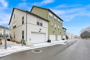 Exterior space with a garage and cooling unit