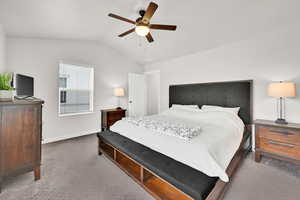 Bedroom featuring lofted ceiling, ceiling fan, and carpet