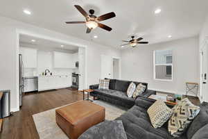 Living room featuring sink, dark wood-type flooring, and ceiling fan